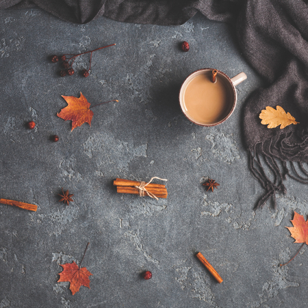 Autumn composition. Cup of coffee, scarf, autumn leaves on black background. Flat lay, top view, squareの写真素材