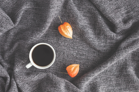 Autumn composition. Cup of coffee, autumn flowers on fabric background. Flat lay, top viewの写真素材