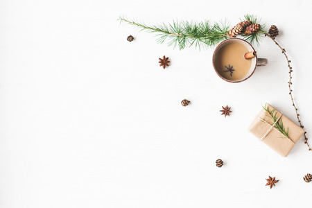 Christmas composition. Cup of coffee, larch branches, cinnamon sticks, anise star. Christmas background. Flat lay, top viewの写真素材