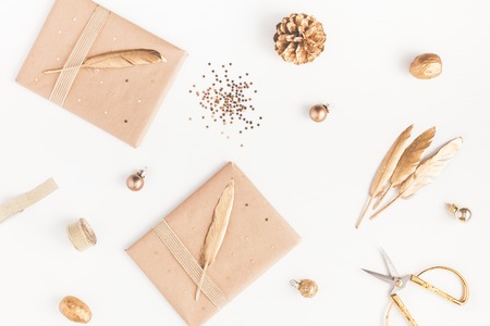 Christmas composition. Christmas gifts, pine cone, golden accessories on white background. Flat lay, top view, close up