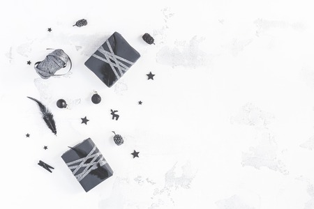 Christmas composition. Christmas gifts, pine cones, black accessories on white background. Flat lay, top view, copy spaceの写真素材