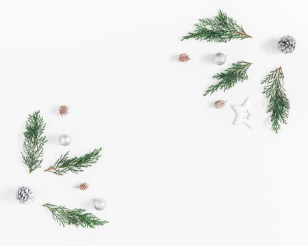 Christmas composition. Frame made of fir branches and silver decorations on white background. Christmas, winter, new year concept. Flat lay, top view, copy spaceの写真素材