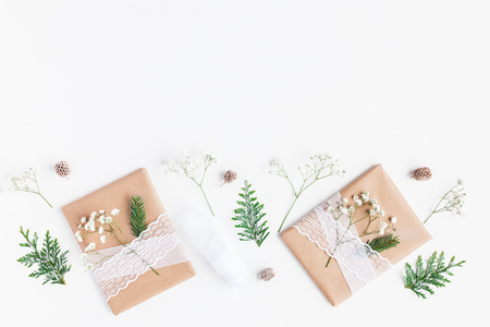 Christmas composition. Christmas gifts, pine cones, gypsophila flowers, thuja branches on white. Flat lay, top view, copy spaceの写真素材