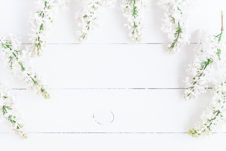 Flowers composition. Frame made of white lilac flowers on white wooden background. Flat lay, top view, copy spaceの写真素材