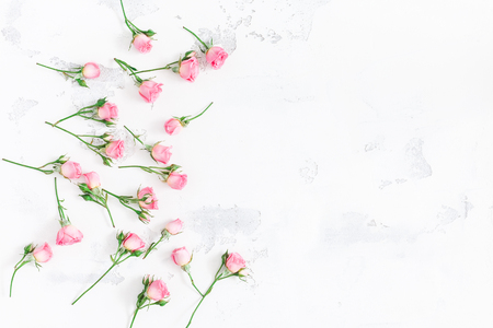 Flowers composition. Frame made of pink rose flowers on white wooden background. Flat lay, top view, copy spaceの写真素材