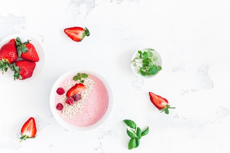 Breakfast with strawberry smoothie, fresh fruits on white background. Flat lay, top viewの写真素材