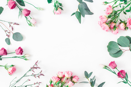 Flowers composition. Frame made of various pink flowers and eucalyptus branches on white background. Flat lay, top view, copy spaceの写真素材