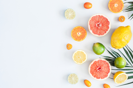 Fruit background. Colorful fresh fruits and tropical palm leaves on pastel blue background. Summer concept. Flat lay, top view, copy spaceの写真素材