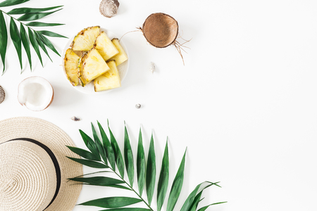 Summer composition. Tropical palm leaves, hat, pineapple, coconut on white background. Summer concept. Flat lay, top view, copy spaceの写真素材