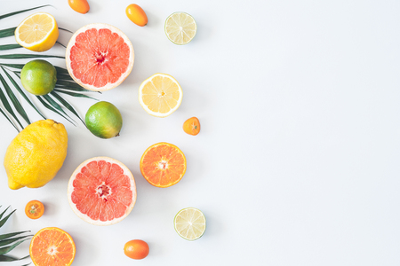 Fruit background. Colorful fresh fruits and tropical palm leaves on pastel blue background. Summer concept. Flat lay, top view, copy spaceの写真素材