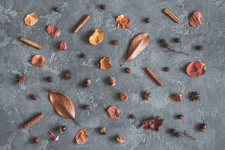 Autumn composition. Pattern made of leaves, flowers, cinnamon sticks, anise stars, nuts, berries on black background. Autumn, fall concept. Flat lay, top viewの写真素材