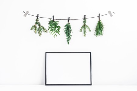 Christmas composition. Black frame and christmas tree branches on white background. Front view, mock up, copy spaceの写真素材