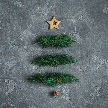 Christmas tree made of cypress branches and golden decorations. Christmas, winter, new year concept. Flat lay, top view, squareの写真素材