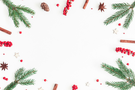 Christmas composition. Frame made of christmas tree branches and red berries on white background. Flat lay, top view, copy spaceの写真素材