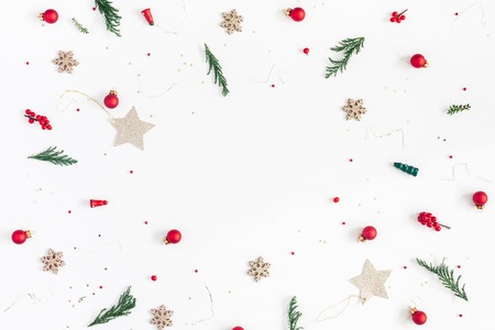 Christmas composition. Frame made of christmas tree branches, golden decorations and red berries on white background. Flat lay, top view, copy spaceの写真素材