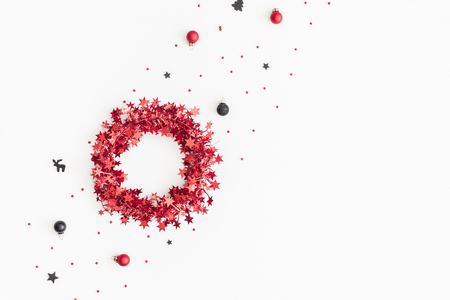 Christmas composition. Christmas wreath, black and red decorations on white background. Flat lay, top view, copy spaceの写真素材