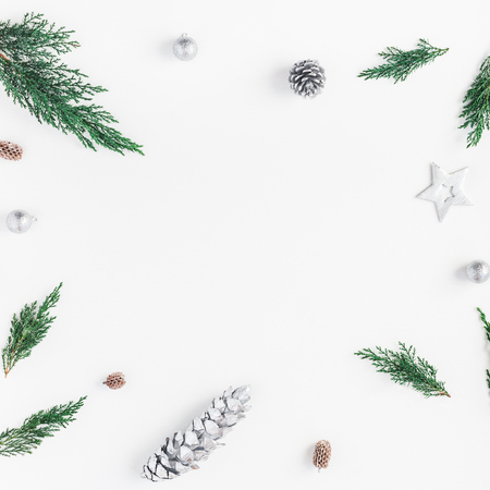 Christmas composition. Frame made of christmas silver decoration, cypress branches, pine cones. Flat lay, top view, copy space, squareの写真素材
