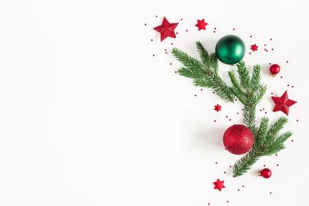 Christmas composition. Fir tree branches, red and green decorations on white background. Christmas, winter, new year concept. Flat lay, top view, copy spaceの写真素材