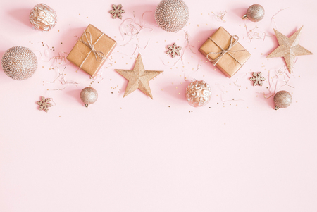 Christmas composition. Christmas gifts, golden decorations on pastel pink background. Flat lay, top view, copy spaceの写真素材