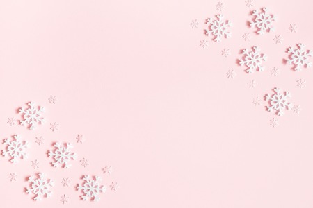 Christmas or winter composition. Frame made of snowflakes on pastel pink background. Christmas, winter, new year concept. Flat lay, top view, copy spaceの写真素材
