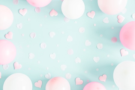 Balloons on pastel blue background. Frame made of white and pink balloons. Birthday, valentines day, holiday concept. Flat lay, top view, copy spaceの写真素材