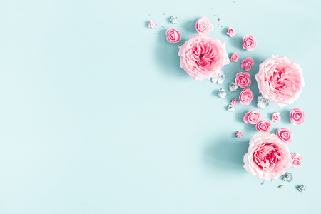 Flowers composition. Frame made of rose flowers on pastel blue background. Valentines day, mothers day, womens day, spring concept. Flat lay, top view, copy spaceの写真素材