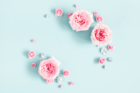 Flowers composition. Frame made of rose flowers on pastel blue background. Valentines day, mothers day, womens day, spring concept. Flat lay, top view, copy spaceの写真素材