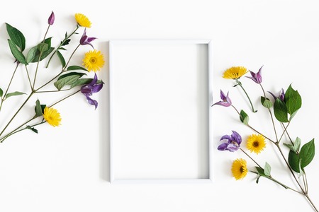 Flowers composition. Purple and yellow flowers, photo frame on white background. Spring, easter concept. Flat lay, top view, copy spaceの写真素材