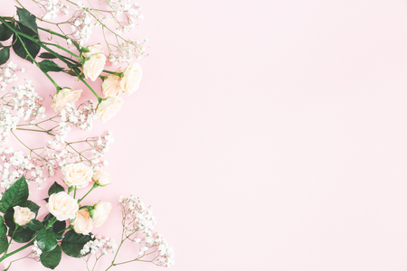 Flowers composition. Rose and gypsophila flowers on pastel pink background. Valentines day, mothers day, womens day concept. Flat lay, top view, copy spaceの写真素材