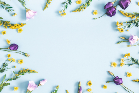 Easter eggs, purple and yellow flowers on pastel blue background. Spring, easter concept. Flat lay, top view, copy spaceの写真素材