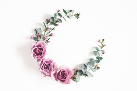 Flowers composition. Wreath made of eucalyptus branches and rose flowers on white background. Flat lay, top view, copy spaceの写真素材