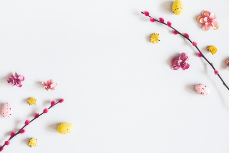 Easter composition. Easter eggs, flowers on pastel gray background. Flat lay, top view, copy space