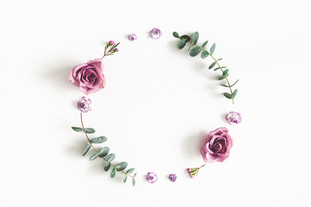 Flowers composition. Wreath made of eucalyptus branches and rose flowers on white background. Flat lay, top view, copy spaceの写真素材