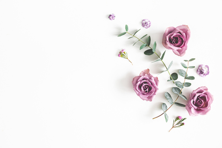 Flowers composition. Pattern made of eucalyptus branches and rose flowers on white background. Flat lay, top view, copy spaceの写真素材