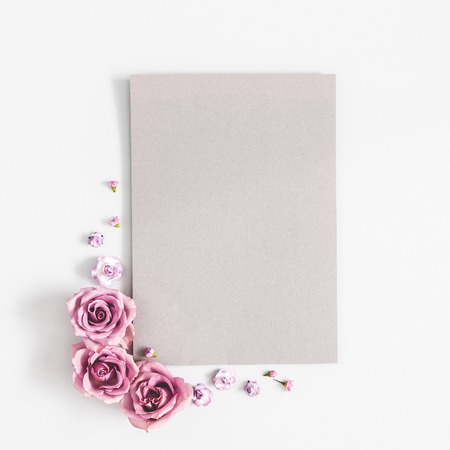 Flowers composition. Paper blank, purple flowers on white background. Flat lay, top view, copy spaceの写真素材