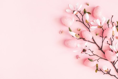Easter composition. Easter eggs, pink flowers on pastel pink background. Flat lay, top view, copy spaceの写真素材