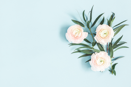 Flowers composition. Pink flowers and eucalyptus leaves on pastel blue background. Flat lay, top view, copy spaceの写真素材