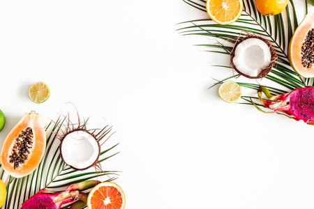 Fruits and palm leaves on white background. Tropical fruits. Summer concept. Flat lay, top view, copy spaceの写真素材
