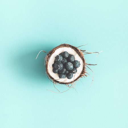 Coconut and blueberry on blue background. Flat lay, top view, squareの写真素材