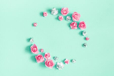 Flowers composition. Frame made of rose flowers on mint background. Flat lay, top view, copy space, squareの写真素材