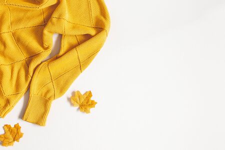 Autumn composition. Sweater, autumn leaves on white background. Flat lay, top view, copy spaceの写真素材