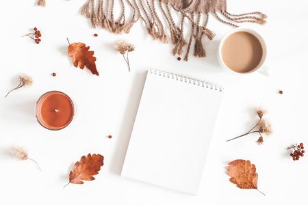 Autumn composition. Cup of coffee, plaid, notepad, autumn leaves on white background. Flat lay, top view, copy spaceの写真素材