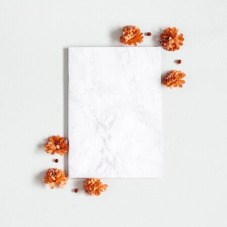 Autumn composition. Paper blank, flowers, leaves on gray background. Autumn, fall, thanksgiving day concept. Flat lay, top view, copy spaceの写真素材