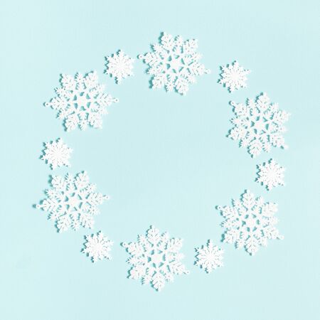 Winter composition. Wreath made of snowflakes on pastel blue background. Winter, new year concept. Flat lay, top view, copy space, squareの写真素材