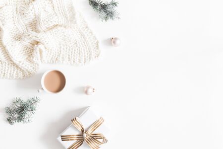 Christmas composition. Gift, fir tree branches, plaid, cup of coffee, balls on white background. Christmas, winter, new year concept. Flat lay, top view, copy spaceの写真素材