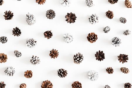 Christmas composition. Pattern made of pine cones on white background. Christmas, winter, new year concept. Flat lay, top viewの写真素材