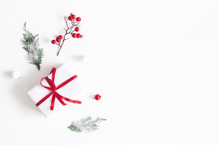Christmas composition. Frame made of gift, snowflakes, fir tree branches and red berries on white background. Christmas, winter, new year concept. Flat lay, top view, copy spaceの写真素材