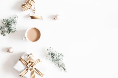 Christmas composition. Gift, fir tree branches, cup of coffee, balls on white background. Christmas, winter, new year concept. Flat lay, top view, copy spaceの写真素材