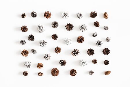 Christmas composition. Pattern made of pine cones on white background. Christmas, winter, new year concept. Flat lay, top viewの写真素材