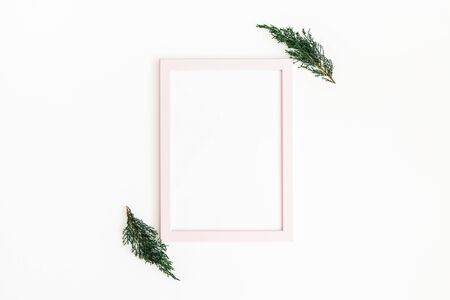 Simple composition. Photo frame, fir tree branches on white background. winter, new year concept. Flat lay, top view, copy spaceの写真素材